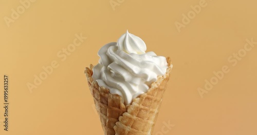Vanilla ice cream in waffle cone close-up on the rotating table.