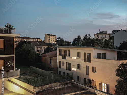 Evening residential neighborhood with illuminated windows in Italian city