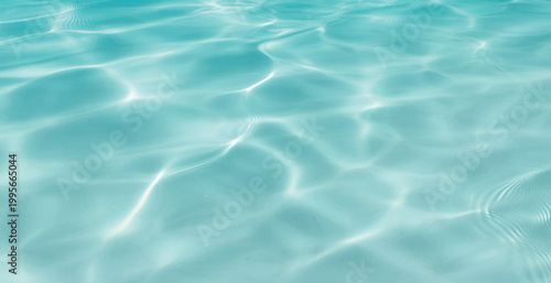 Serene Aqua Water Surface with Gentle Ripples, Bright Sunlight Reflections, Crystal Clear Pool Water Background with Light Patterns