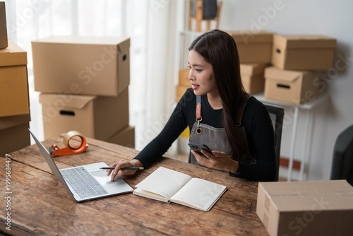 Small business owner managing online orders at desk