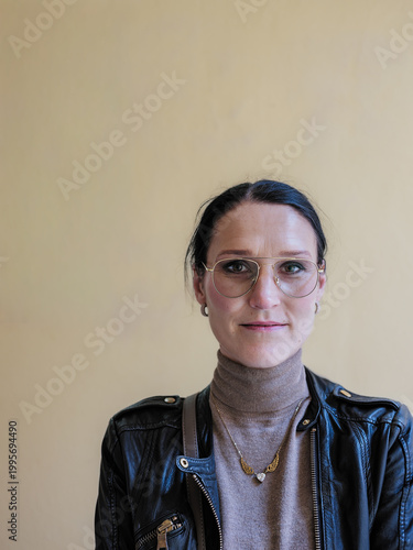Portrait of elegant woman with glasses looking away against neutral background