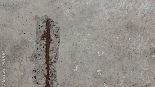 Exposed rusted rebar in spalled concrete surface with aggregate detail