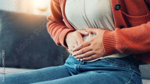 Tableau sur toile Cramps, menstruation and hands of woman on sofa in home for period pain, healthcare and stomach virus