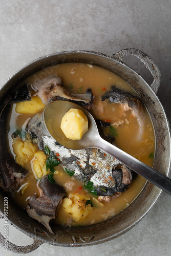 Photos Overhead view of Nigerian pepper soup with catfish and potatoes in a pot, top vi