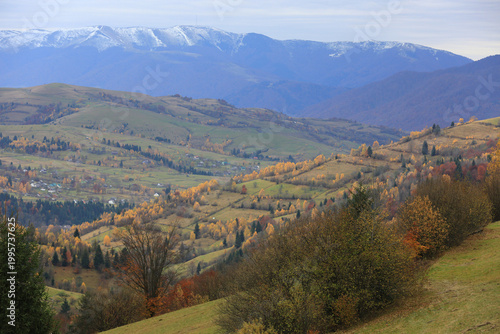 Rolling hills and distant mountains under a cloudy sky in autumn