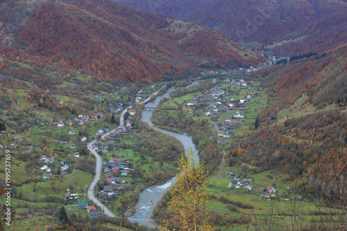 Scenic mountain village nestled in a valley during autumn foliage season
