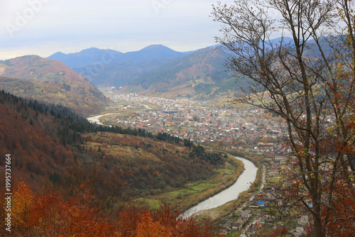 Scenic mountain valley town with winding river during autumn foliage season