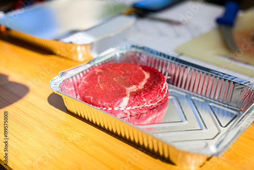 A perfectly trimmed and trussed raw ribeye steak sits on a wooden cutting board with a metal skewer, prepared for high-stakes professional grilling at a Steak Cookoff Association (SCA) BBQ competition