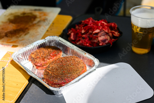 A perfectly trimmed and trussed raw ribeye steak sits on a wooden cutting board with a metal skewer, prepared for high-stakes professional grilling at a Steak Cookoff Association (SCA) BBQ competition