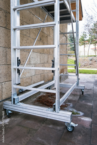 Portable aluminum rolling scaffold tower with wheels for safe access, used in building maintenance and construction tasks
