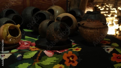 Terracotta vessels arranged on embroidery rug with inviting atmosphere