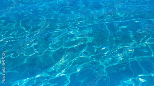 The  blue crystal clear water background for summer vacation concept. Beach nature and summer seawater with sunlight light  beach Sparkling sea water