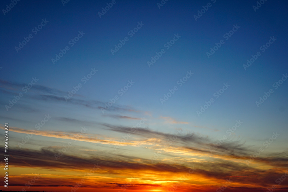 Obraz premium A dramatic sunset in a sky of bright orange and red hues