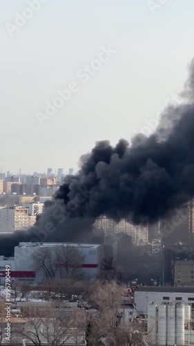 Thick black smoke from large urban fire, environmental pollution and disaster concept