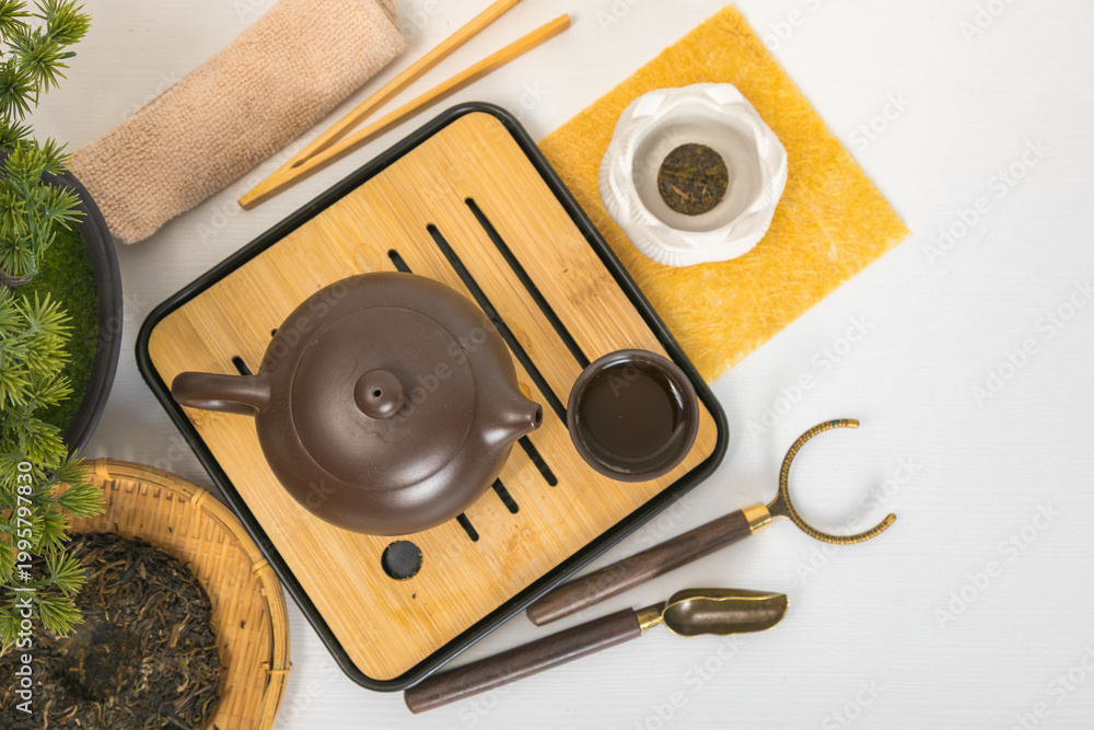 Obraz premium Traditional Yixing teapot on bamboo chaban tray with tea leaves and cup. Chinese tea ceremony accessories for Zen meditation, relaxation and wellness. Healthy beverage ritual concept