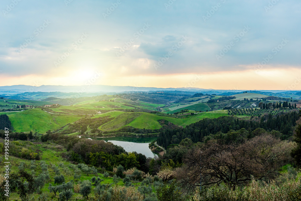 Naklejka premium Tuscany hills landscape with lake at sunset in Castelfalfi