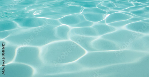 Serene Aqua Water Surface with Gentle Ripples, Bright Sunlight Reflections, Crystal Clear Pool Water Background with Light Patterns