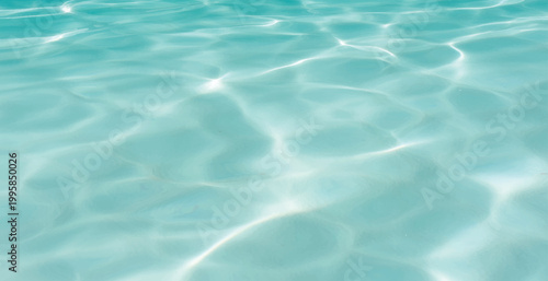 Serene Aqua Water Surface with Gentle Ripples, Bright Sunlight Reflections, Crystal Clear Pool Water Background with Light Patterns