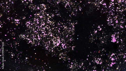 Pink and gold glitter particles floating in dark abstract background