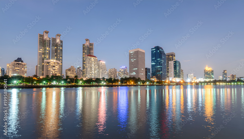 Obraz premium Modern city skyline at dusk with colorful waterfront reflections.