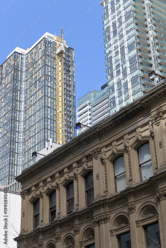 Naklejka premium elegant stone facade of Consumer's Gas Company, designed by Grant & Dick, located at 19-23 Toronto St, contrast with recent condominium, Toronto