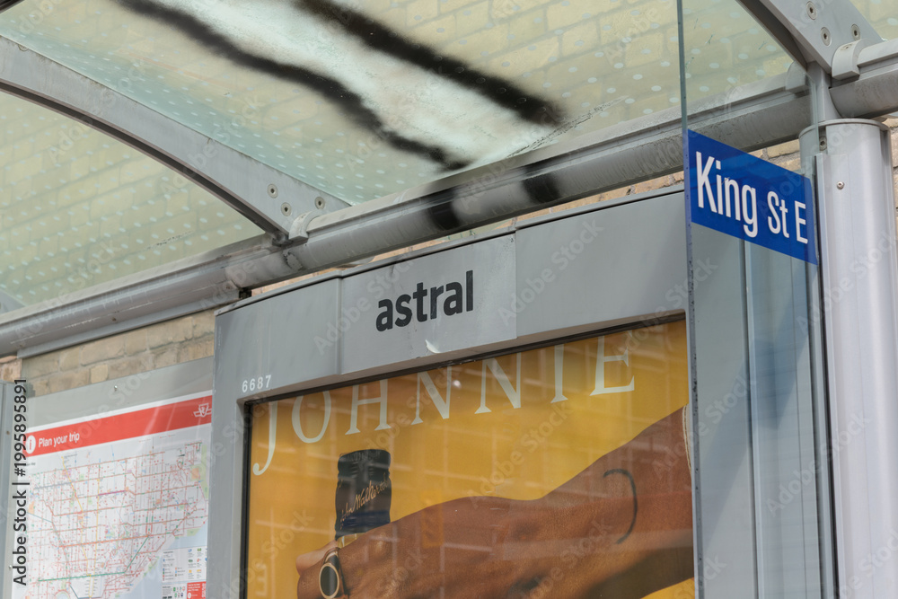 Obraz premium detail of a bus shelter on King St E with out of home advertising for alcohol, and a TTC route map in Toronto