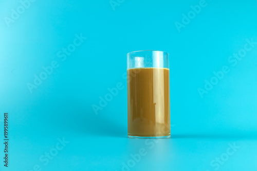 A coffee drink contained in a glass on a plain background