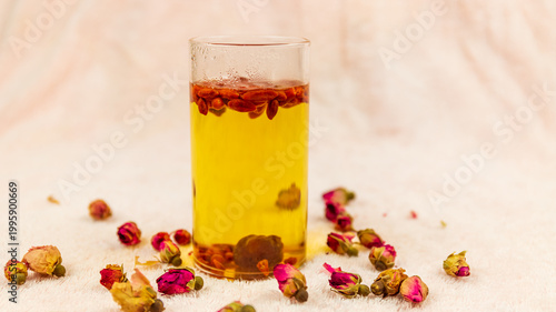 The water made from dried red dates and goji berries in the transparent glass cup