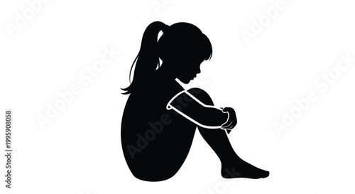 Silhouette of a lonely young girl sitting on the floor feeling very sad and depressed