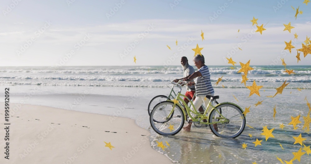 Fototapeta premium Walking pair pushing green bikes on beach barefoot prints waves gold-star overlay, copy space