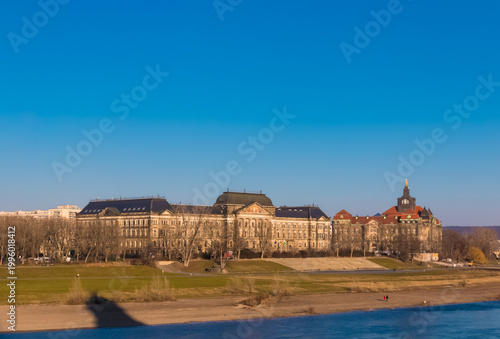 Beautiful view of the Neustädter Elbufer, the north‑bank riverside promenade along the Elbe River in Dresden with the sunlit Saxon Ministry of Finance and the historic Ministerial Building.