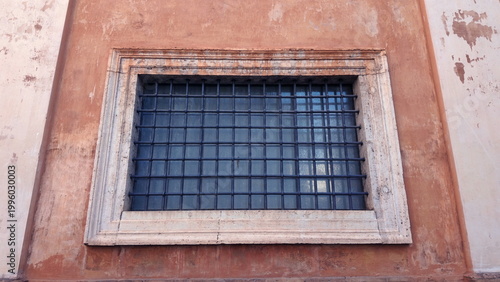 Schilderij op canvas Close-up of barred window set in weathered orange wall of Vatican City building
