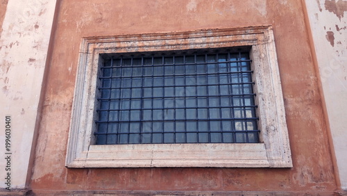 Foto Close-up of barred window set in weathered orange wall of Vatican City building
