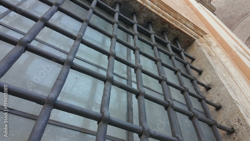Fotografie Angled view of iron bars on historic window in Vatican City showing texture and
