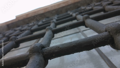 Foto Extreme low angle of metal bars on historic window in Vatican City emphasizing p