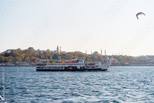 Foto Traditional Istanbul ferry crossing the Bosphorus with seagulls and the historic peninsula skyline on a clear autumn day
