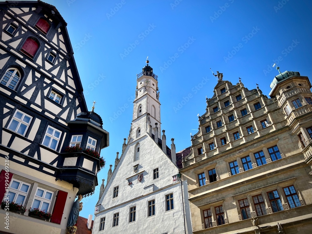 Fototapeta premium Rothenburg ob der Tauber's Town Hall in Bavaria, Germany, is a blend of Gothic and Renaissance architecture. The image shows its white tower with a steep roof and clock