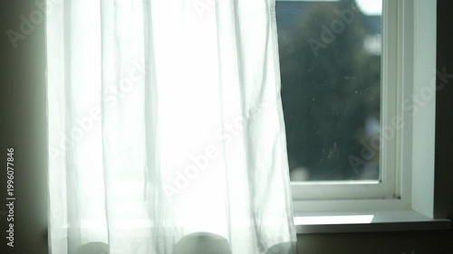 White Sheer Curtain Blowing in the Wind at a Sunny Window