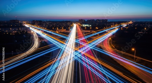 Nighttime Highway Intersection Long Exposure Captures Car Light Trails in Urban Landscape.