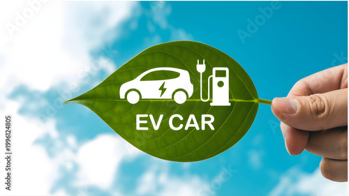 A hand holds a green leaf with an electric car logo under a sunny sky