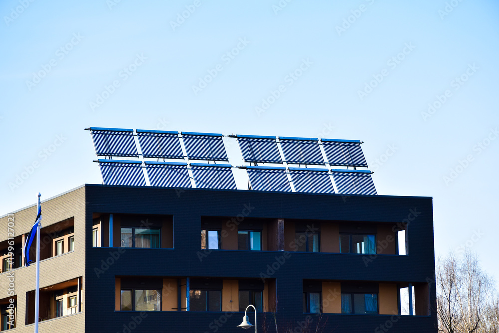Fototapeta premium Solar vacuum tube collectors on the rooftop of a modern apartment building