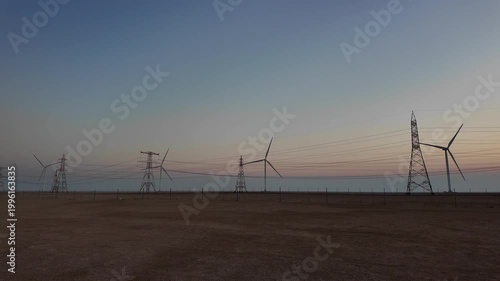 Wind turbines rise along the Saudi–UAE road, converting wind into energy and inspiring a vision of sustainable progress.