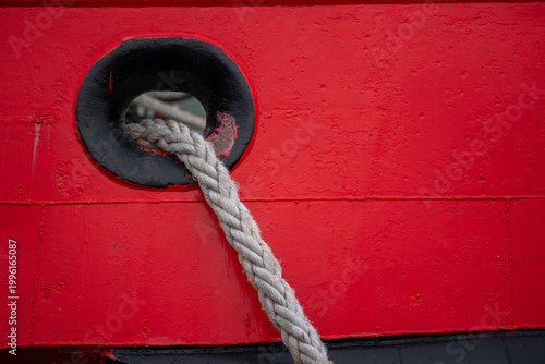 Thick Mooring Rope Through Red Ship Hull