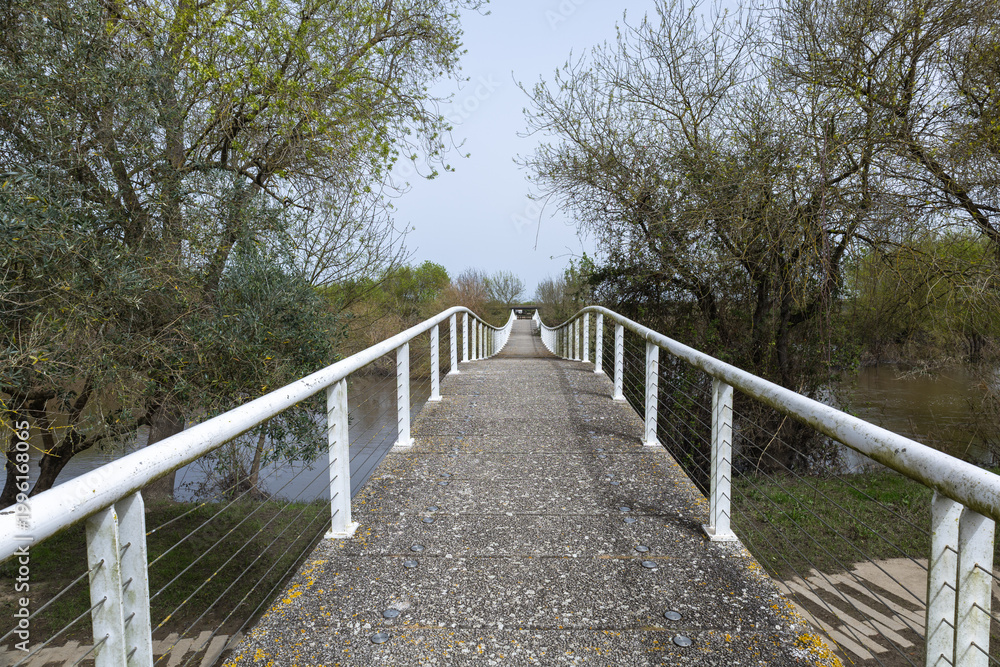 Obraz premium Concrete footbridge crossing sorraia river during flood in benavente