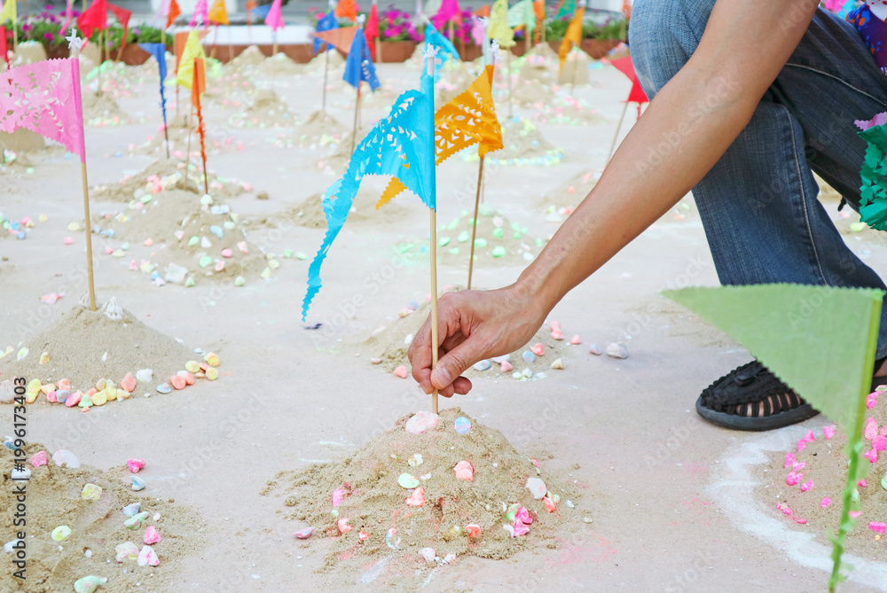 Naklejka premium Visitor Building Sand Pagoda at Wat Suthat to Join the Songkran New Year ceremony with colorful flags and communal ritual