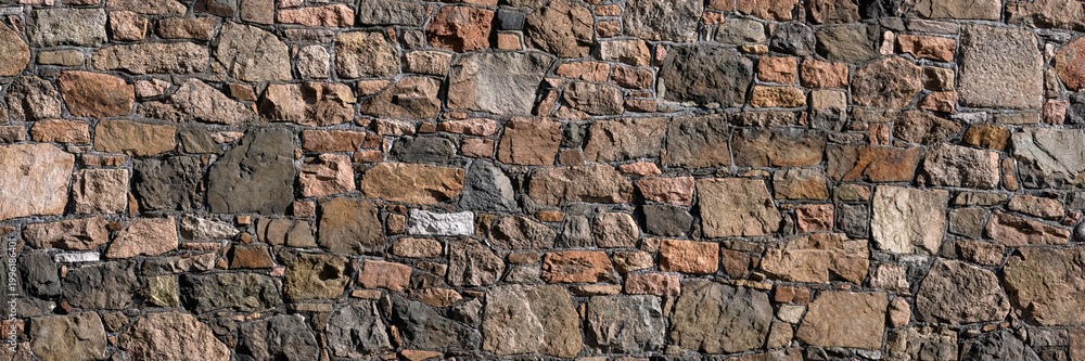 Fototapeta premium Panorama of rough granite stone wall for use as a background texture
