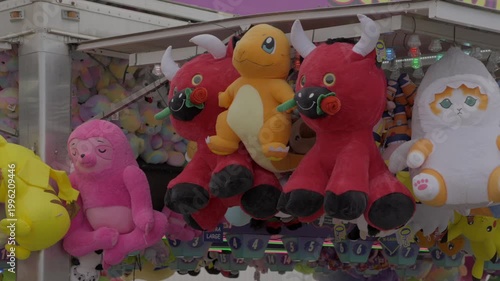 This panning video shows colorful stuffed animal prizes on display at a carnival county fair game. 