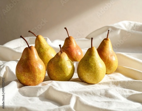 Six ripe organic pears with varied green and reddish yellow skin are beautifully arranged on a soft white linen tablecloth, bathed in natural light, creating a rustic still life