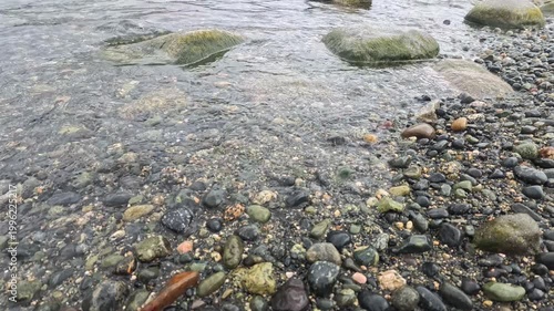 Haines - Alaska - USA - April 21 - Close up view of a shallow stream flowing over smooth rocks and pebbles. The water is clear and creates ripples as it passes over the stones.