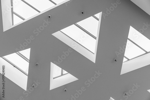 Photos Minimal modern ceiling design with triangular skylights creating a geometric pattern of natural light and shadow
